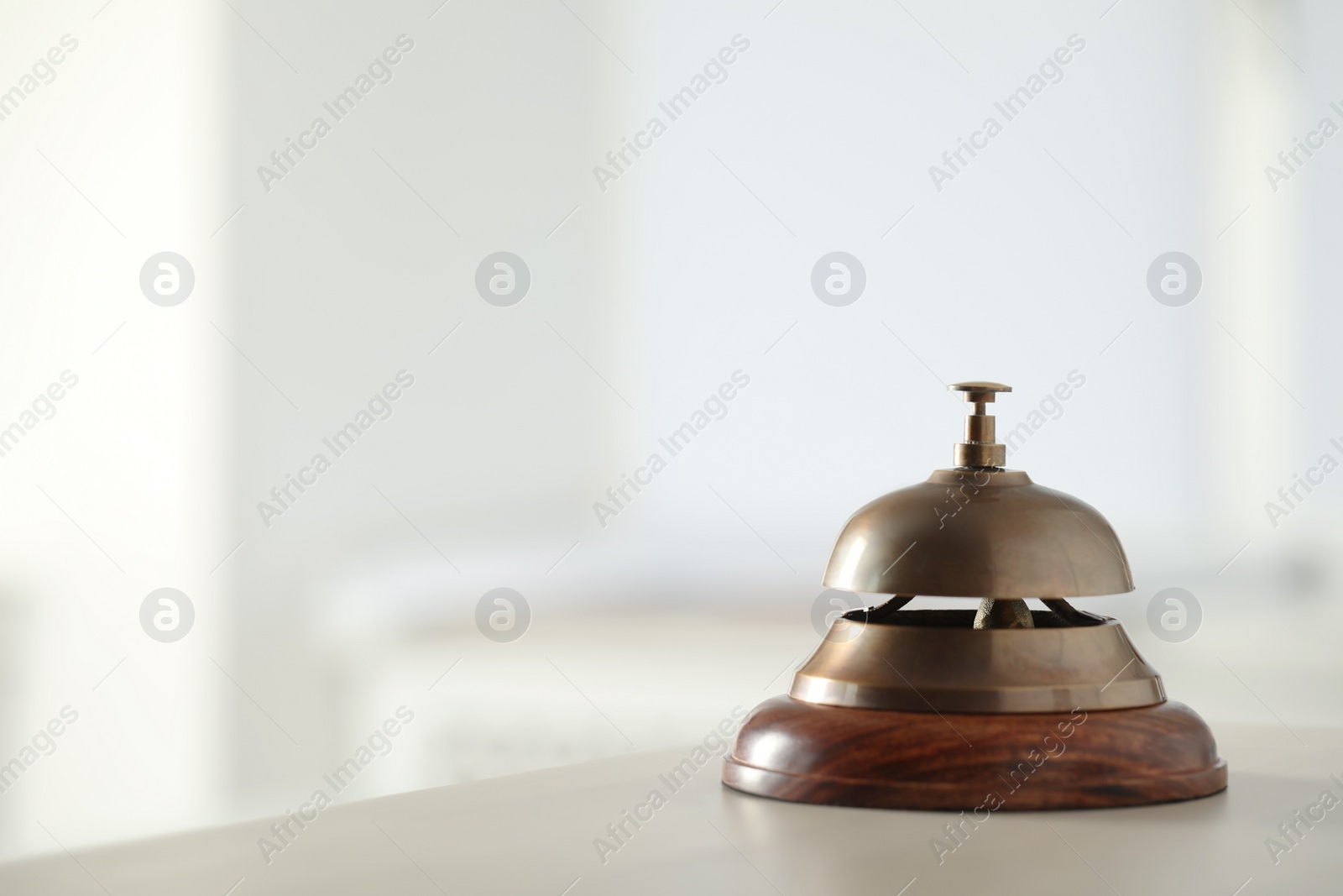 Photo of Hotel service bell on table indoors. Space for text