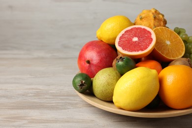 Different ripe fruits on light wooden table, closeup. Space for text