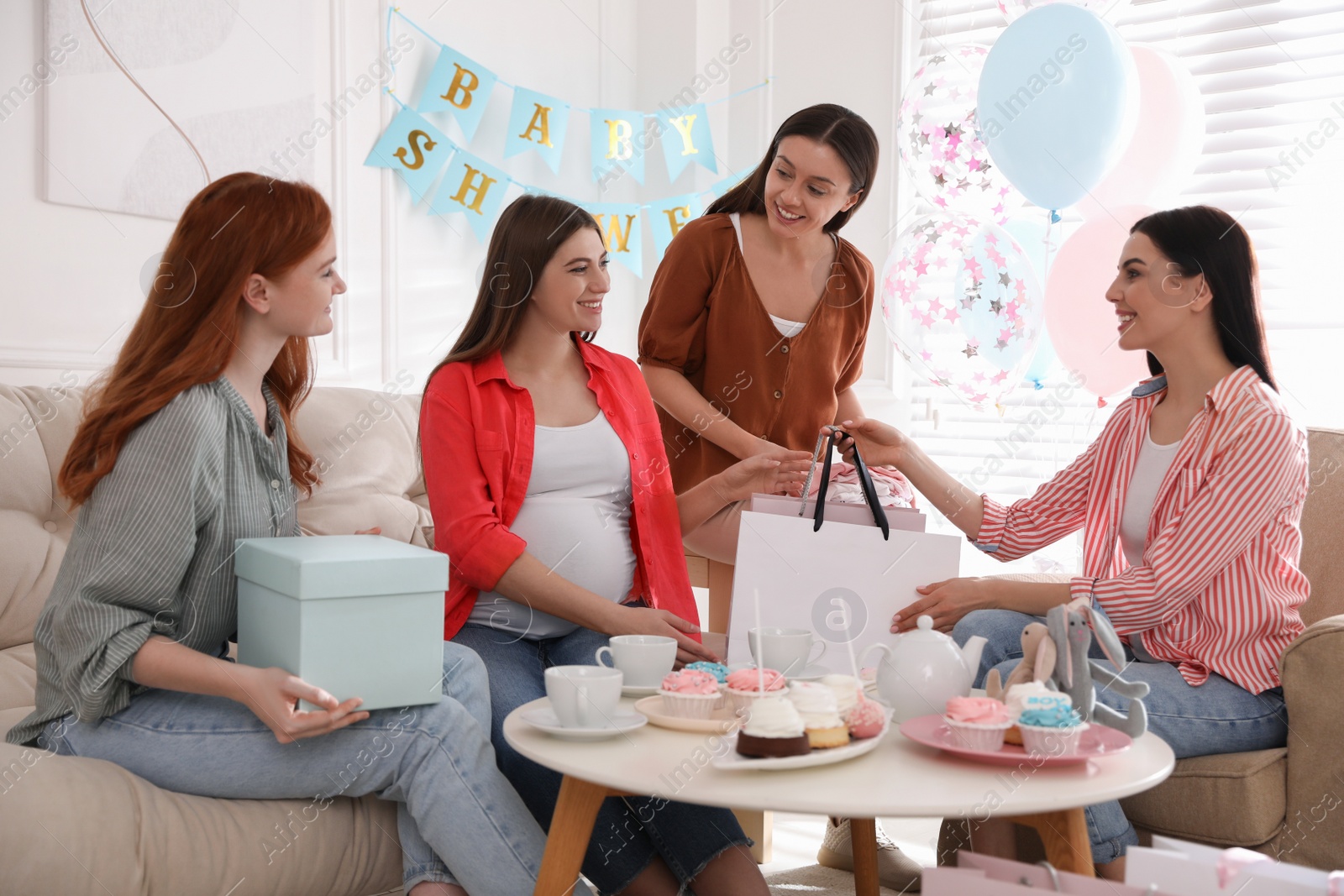 Photo of Happy pregnant woman spending time with friends at baby shower party