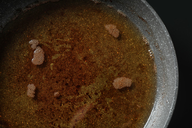 Photo of Used cooking oil in frying pan, closeup