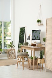 Photo of Stylish room interior with comfortable workplace. Home office