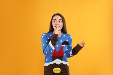 Photo of Young woman in Christmas sweater on yellow background
