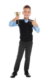 Photo of Happy boy in school uniform with golden winning cup isolated on white