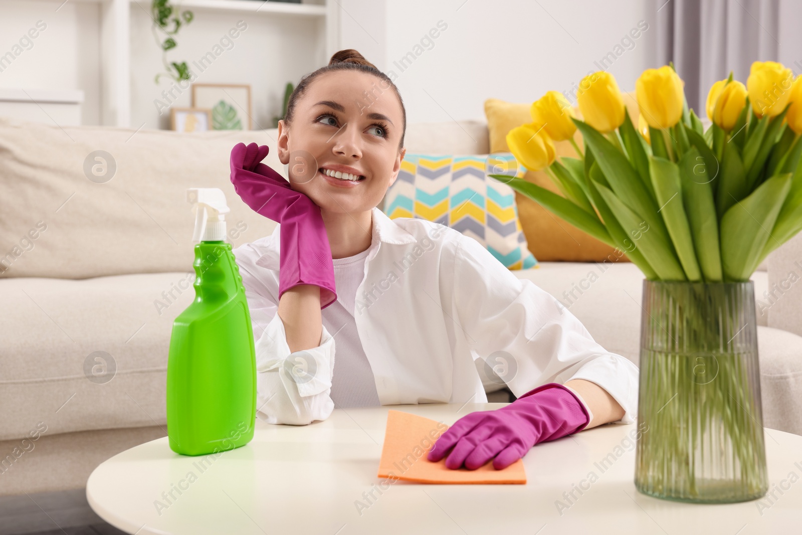 Photo of Spring cleaning. Young woman tidying up living room at home