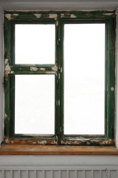 Photo of Old window with empty wooden sill in room