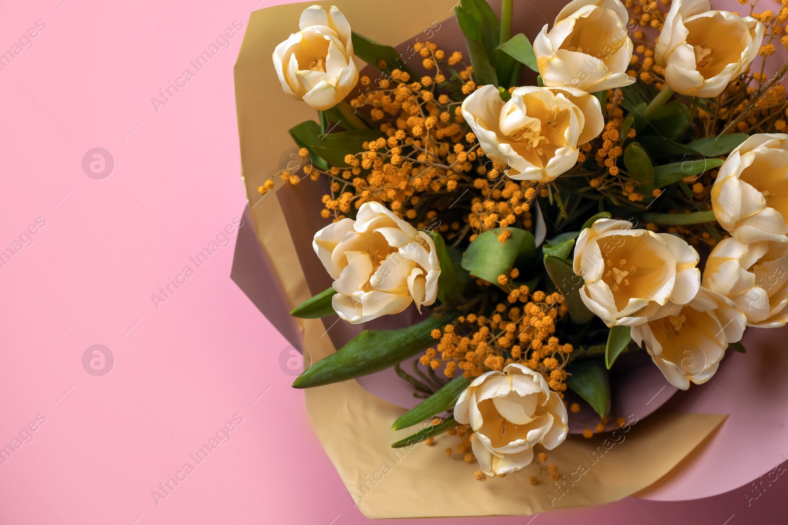 Photo of Bouquet with beautiful tulips and mimosa flowers on pink background, top view. Space for text