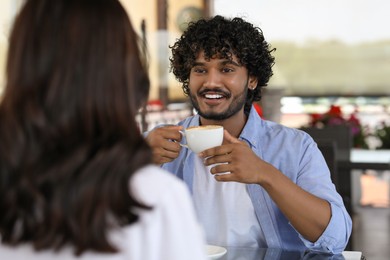 Photo of International dating. Lovely couple enjoying tasty coffee in cafe