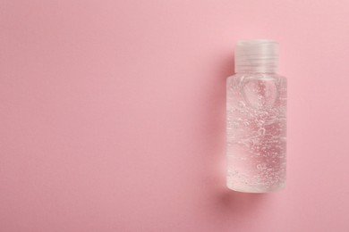 Bottle of cosmetic gel on pink background, top view. Space for text