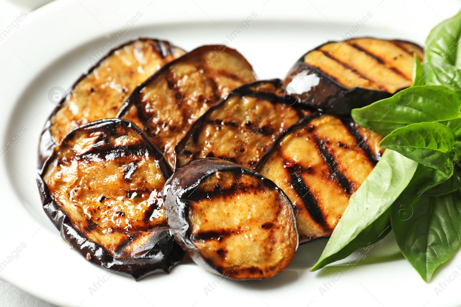 Photo of Plate with tasty fried eggplant slices, closeup