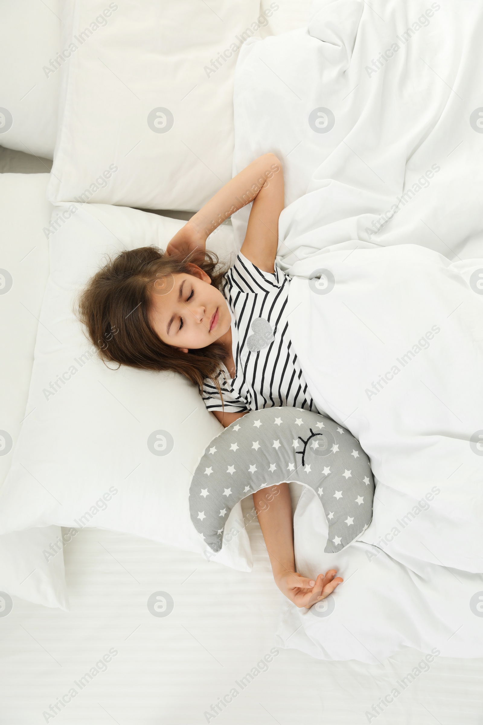 Photo of Cute little girl with toy sleeping in bed, above view