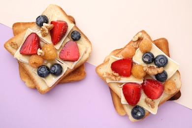 Tasty sandwiches with brie cheese, fresh berries and walnuts on color background, flat lay