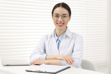 Photo of Medical consultant with glasses at table in clinic