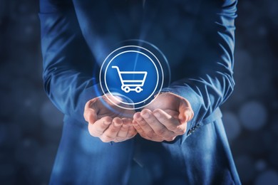 Image of Man demonstrating virtual icon of shopping cart, closeup. Online store