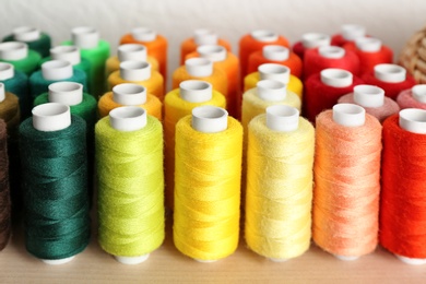 Photo of Set of color sewing threads on wooden shelf
