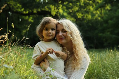 Photo of Beautiful mother with her cute daughter spending time together outdoors