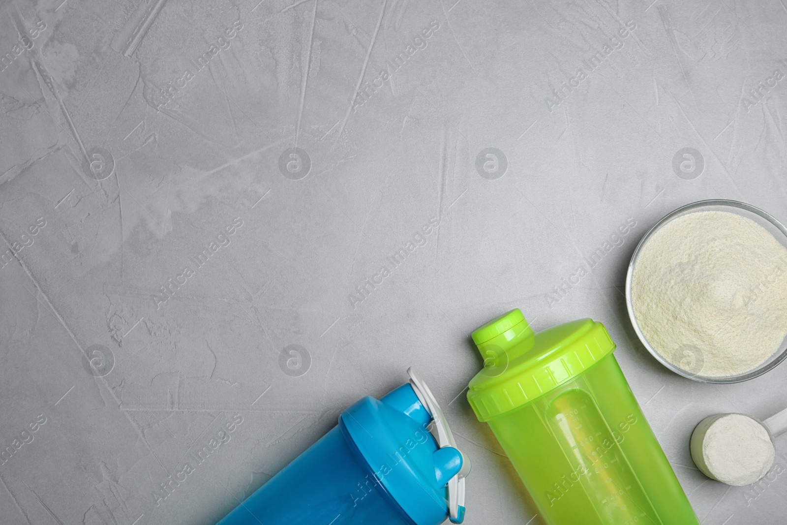 Photo of Bottles, protein powder and space for text on grey background, top view. Preparing shake