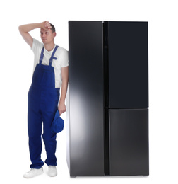 Photo of Professional worker near refrigerator on white background