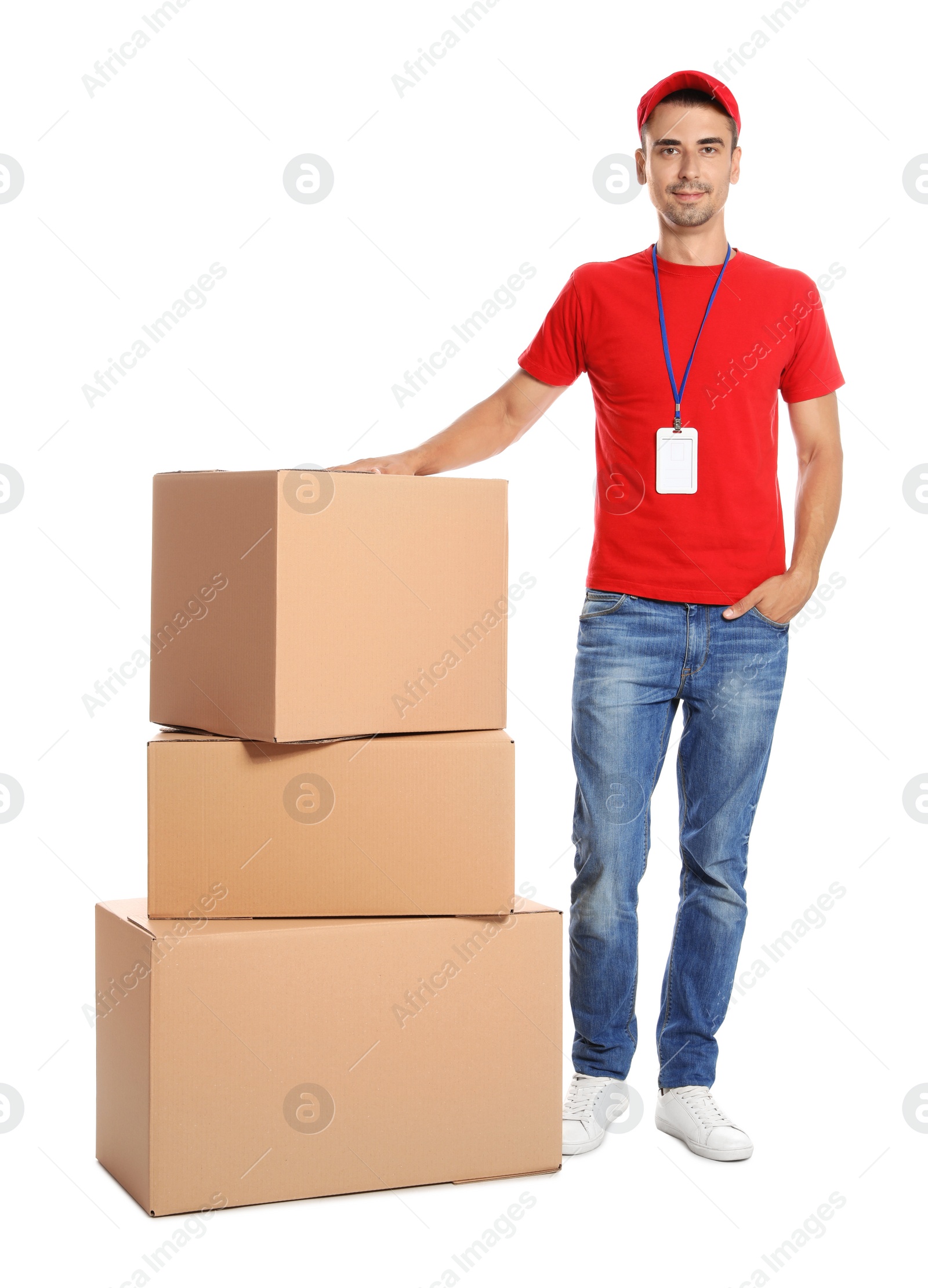 Photo of Young happy courier near pile of cardboard boxes on white background