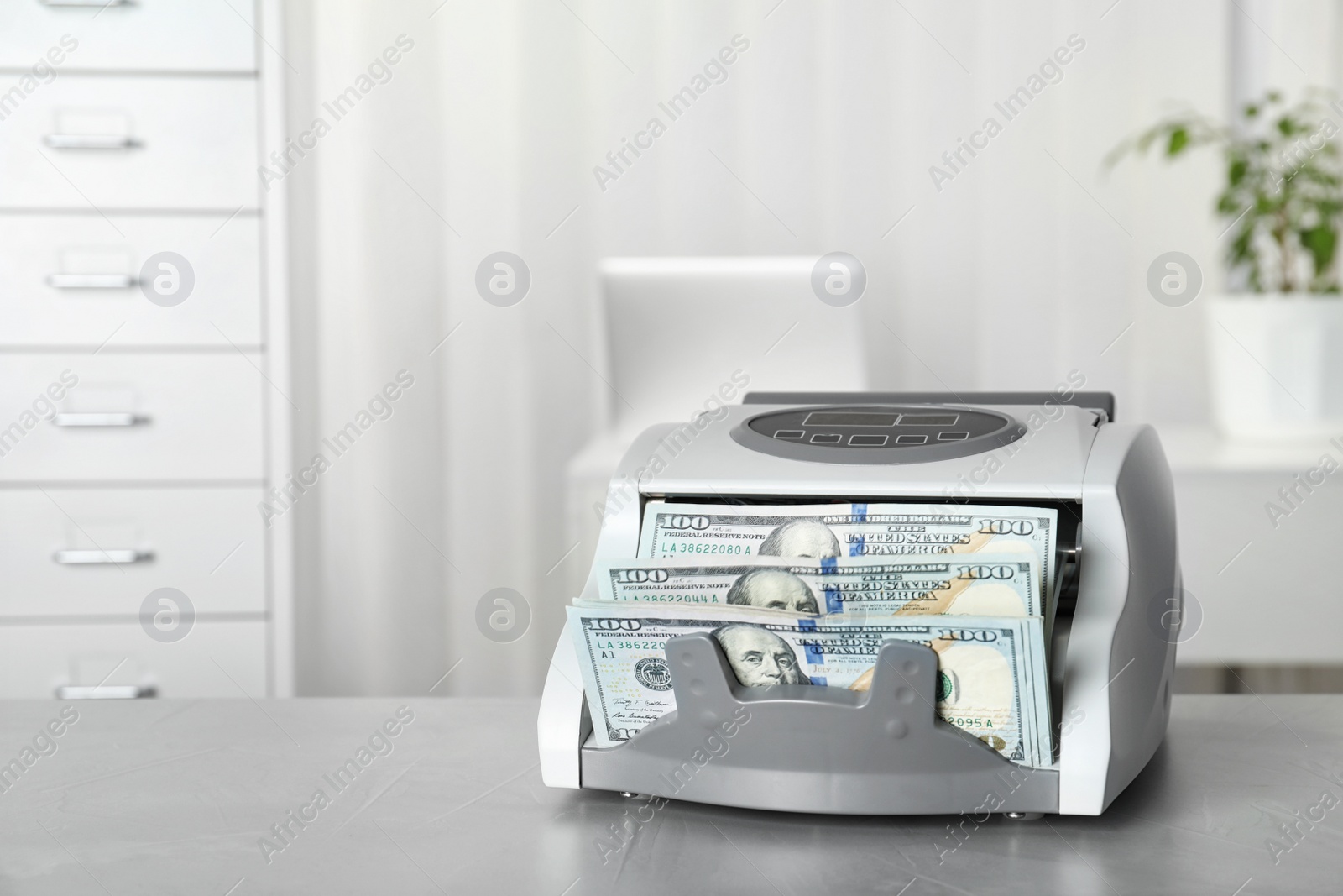 Photo of Modern bill counter with money on table indoors. Space for text