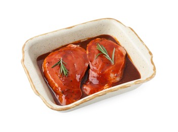 Photo of Raw marinated meat and rosemary in baking dish isolated on white