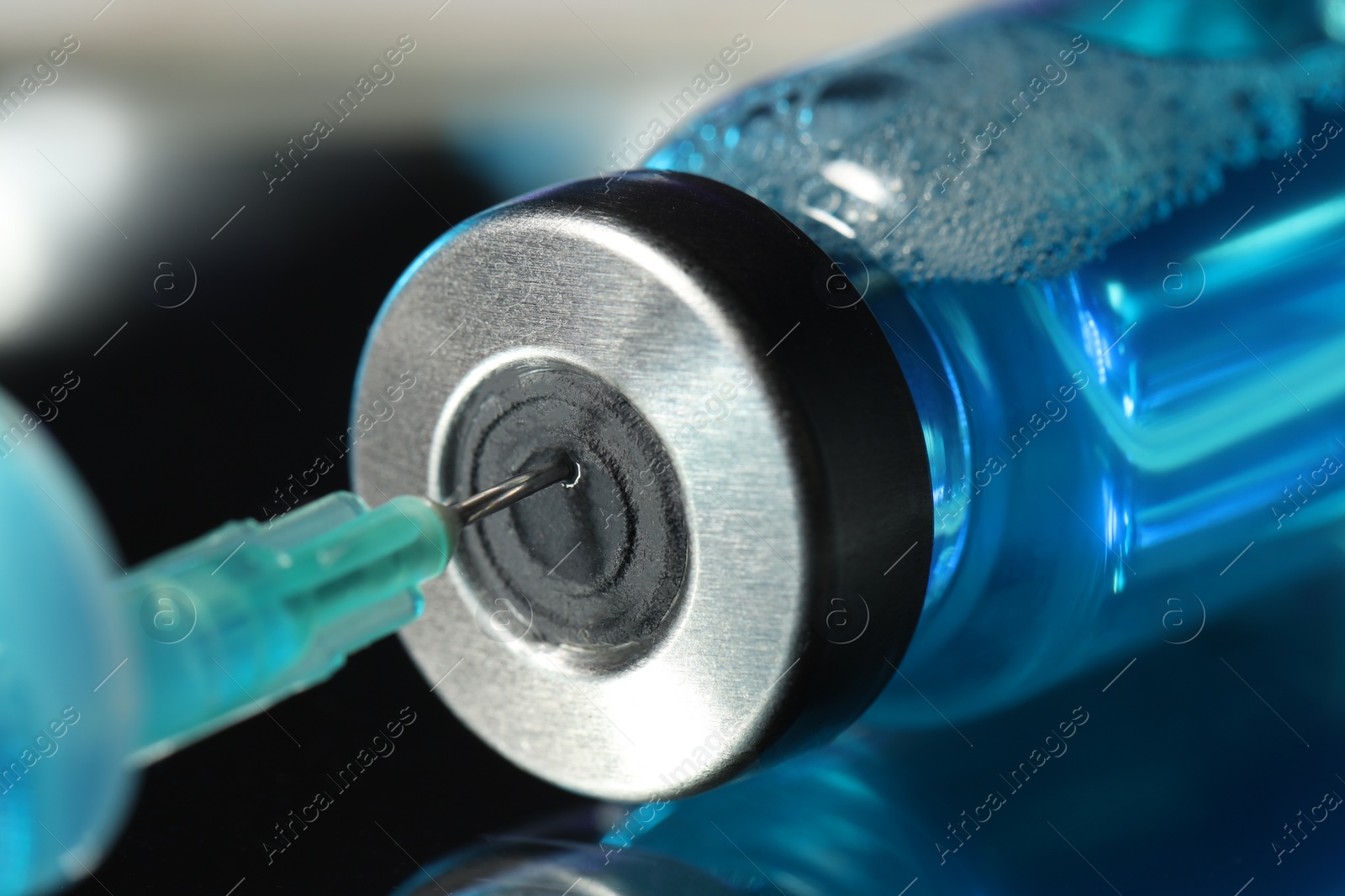 Filling syringe with medicine from vial on table, closeup Photo of Filling syringe with medicine from vial on table, closeup