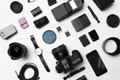 Photo of Flat lay composition with equipment for professional photographer on wooden background