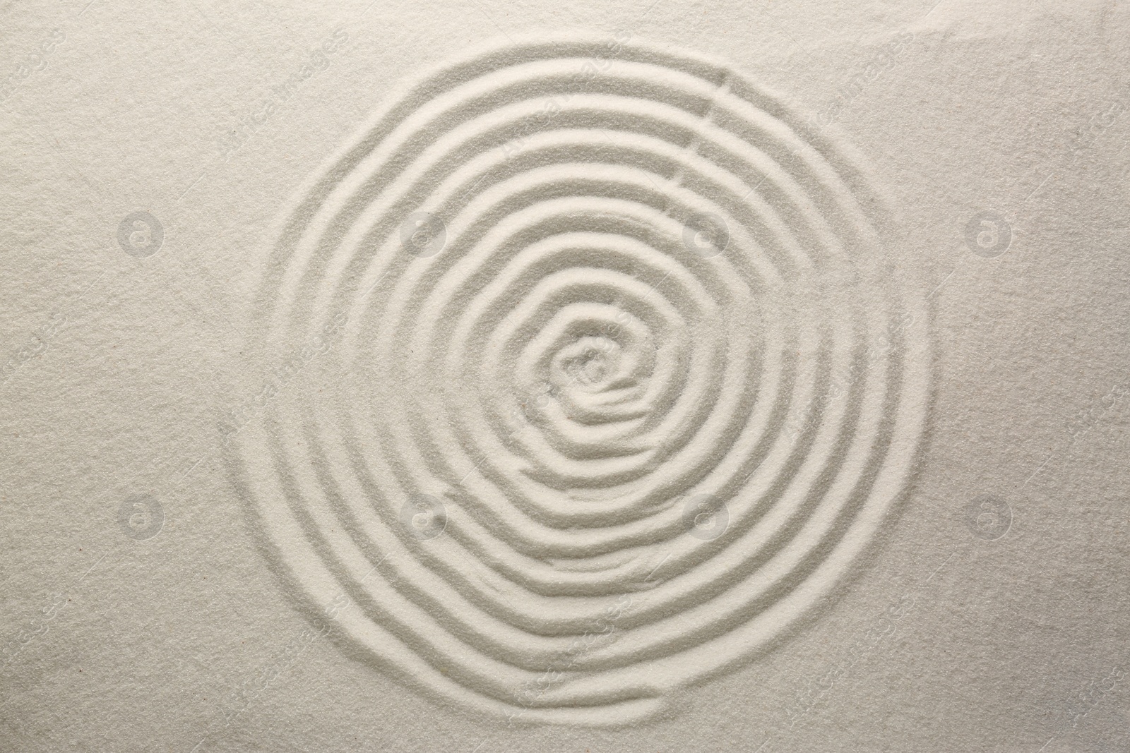 Photo of Beautiful spiral on sand, top view. Zen garden