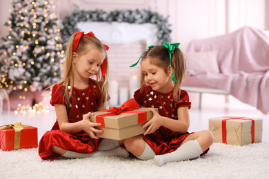 Photo of Cute little children with Christmas gifts at home