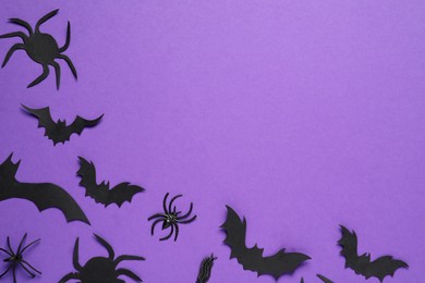 Photo of Flat lay composition with paper bats and spiders on purple background, space for text. Halloween decor