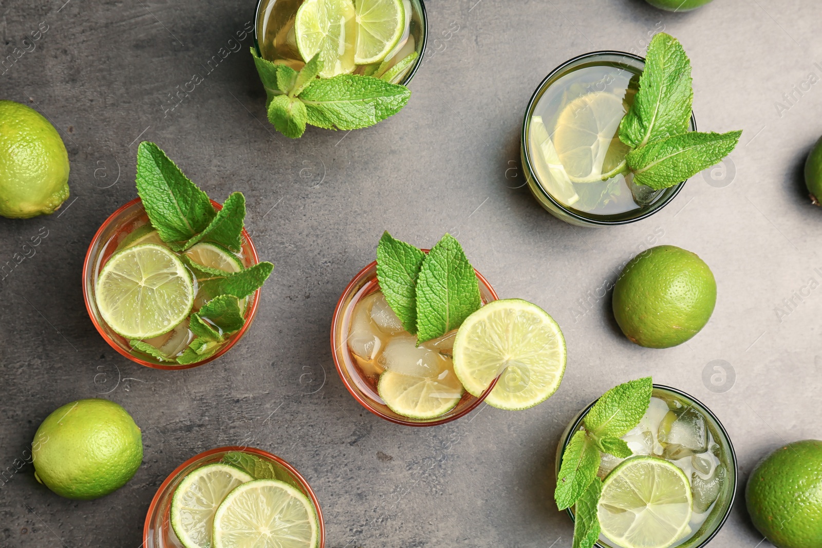 Photo of Flat lay composition with mint julep cocktail in glasses on grey background