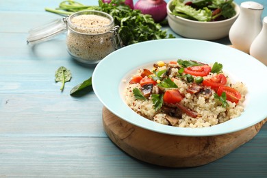 Photo of Plate of tasty quinoa porridge with fried bacon, mushrooms and vegetables on light blue wooden table, closeup. Space for text