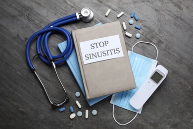 Photo of Notebook with phrase STOP SINUSITIS, stethoscope, non-contact thermometer, medical mask and different drugs on grey background, flat lay