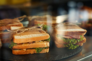 Photo of Showcase with yummy sandwiches in cafe, closeup