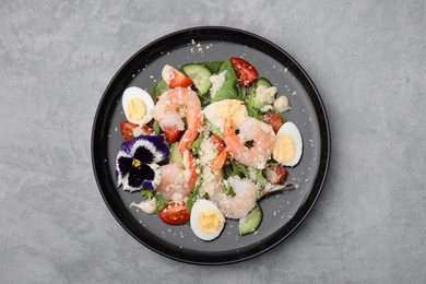 Delicious Caesar salad with shrimps on grey table, top view