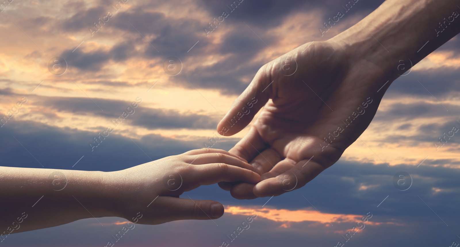 Image of Godparent with child and beautiful sky with clouds at sunset on background, closeup