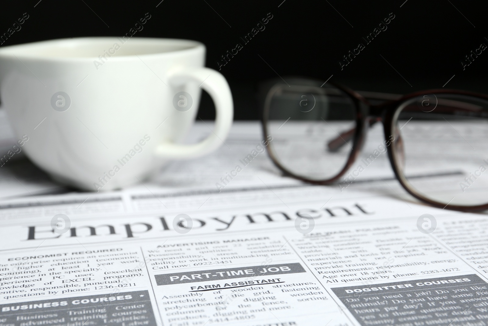 Photo of Cup and glasses on newspaper. Search concept