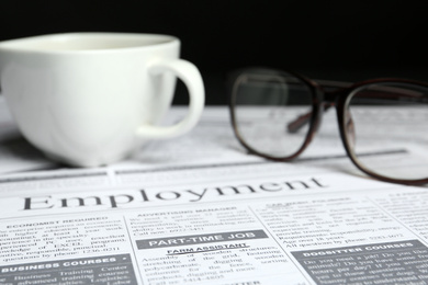 Photo of Cup and glasses on newspaper. Search concept