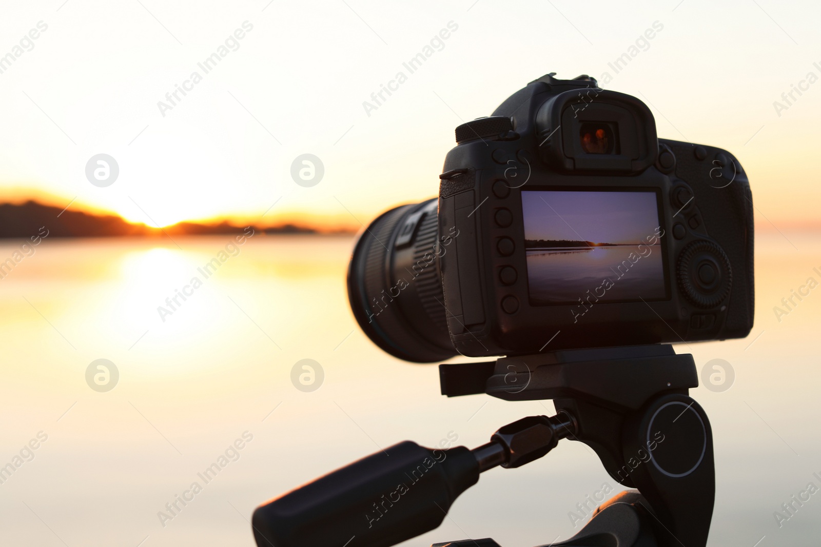 Photo of  beautiful riverside sunset on display of professional camera, closeup