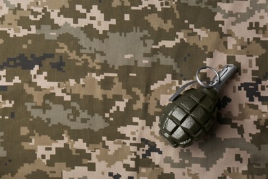 Photo of Hand grenade on digital camouflage fabric, top view. Space for text