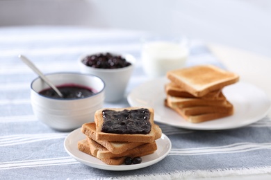 Photo of Delicious breakfast with toasts and jam on table in kitchen