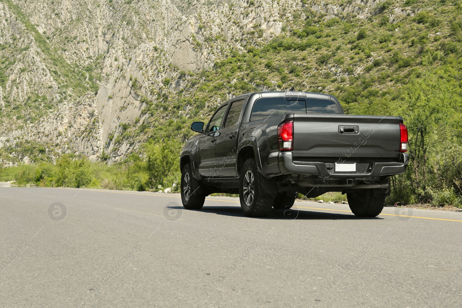 Photo of Black car on road near beautiful mountains outdoors