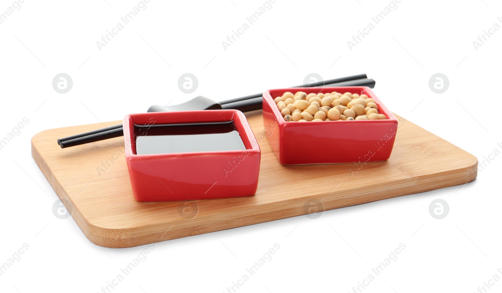 Photo of Wooden board with dishes of soy sauce and beans on white background