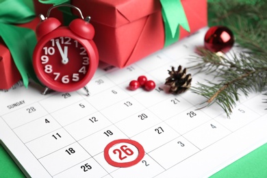 Photo of Composition with calendar and gifts on green background, closeup. Boxing day concept