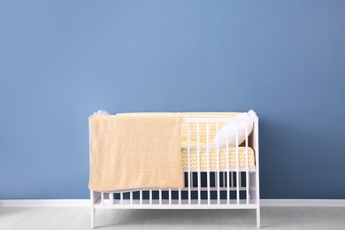 Photo of Baby room interior with crib near wall