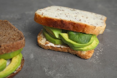 Photo of Tasty avocado sandwiches on grey table, closeup