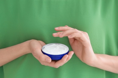 Photo of Young woman with jar of hand cream, closeup