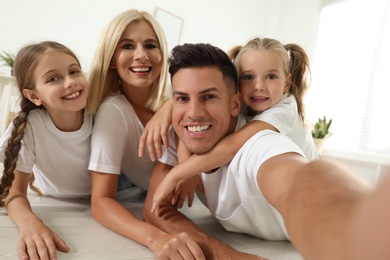 Happy family taking selfie on floor at home