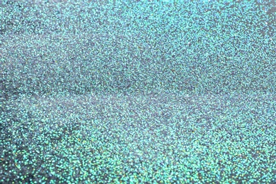 Photo of Closeup view of sparkling blue glitter background