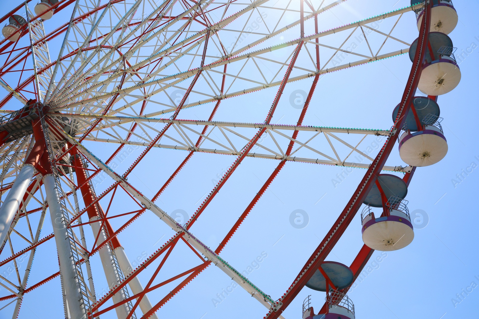 Photo of Beautiful large Ferris wheel against blue sky, low angle view