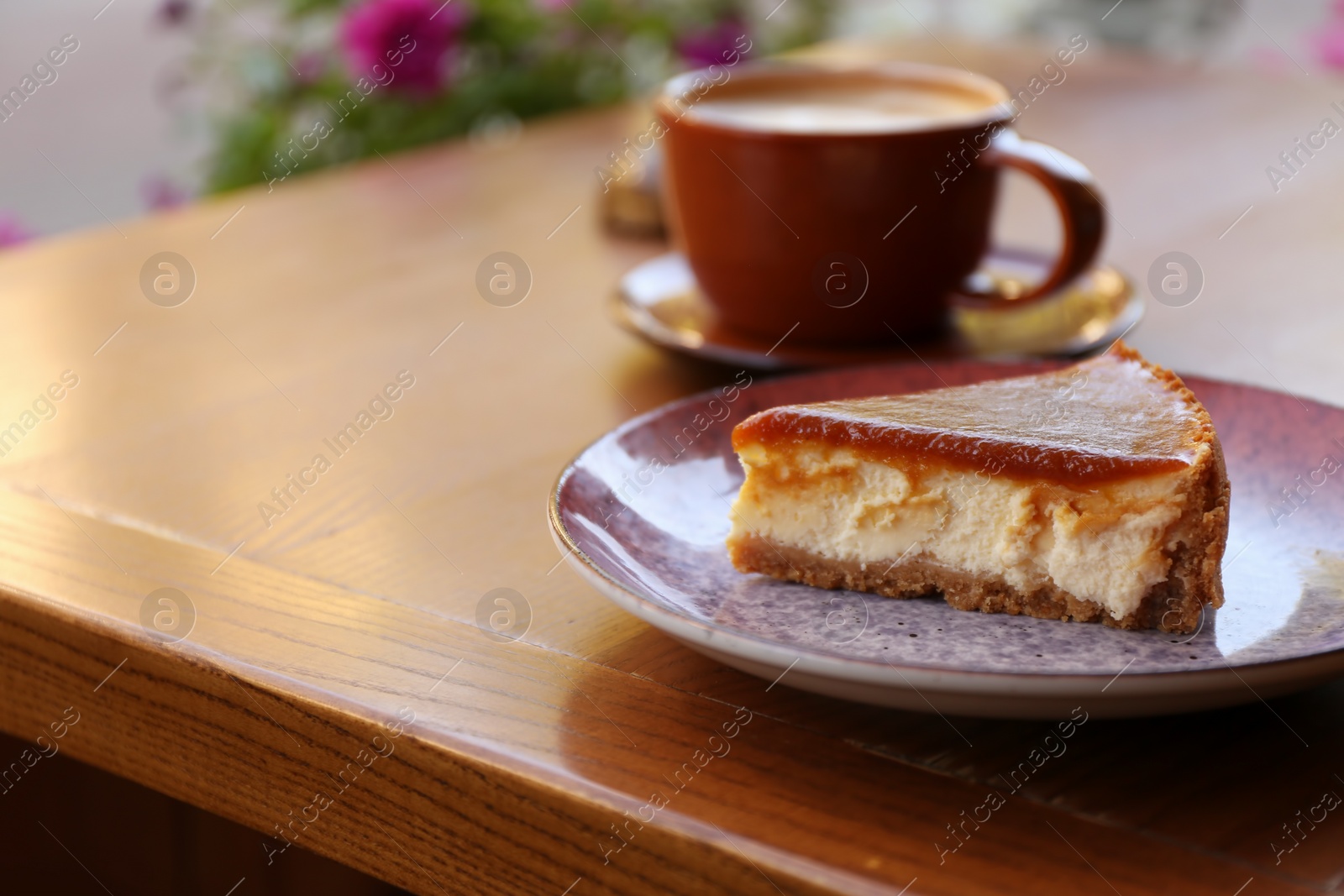 Photo of Plate with slice of cake on wooden table